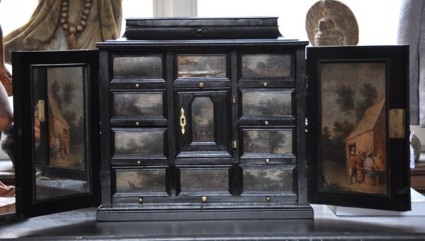 Cabinet flamand du 17ème en bois noirci à deux portes découvrant huit tiroirs autour d'une niche centrale à décor de paysages animés (quelques manques) 46 x 48 x 30cm